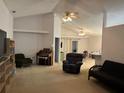 Open-concept living room with vaulted ceilings and neutral tones, perfect for relaxation and entertainment at 1011 Tequesta Trl, Lake Wales, FL 33898