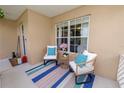 Inviting front porch with cozy seating, decorative pillows and a colorful striped rug at 114 Ed Padgett Rd, Lakeland, FL 33809