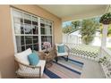 Inviting front porch with cozy seating, decorative pillows and a colorful striped rug at 114 Ed Padgett Rd, Lakeland, FL 33809