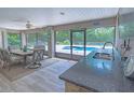 Screened-in patio with an outdoor kitchen and bar seating overlooking the sparkling in-ground pool at 13 Count Fleet Dr, Ocala, FL 34482