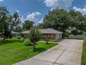 Beautiful exterior view of the home with a large driveway and lush green landscaping at 1308 Timberidge N Loop, Lakeland, FL 33809