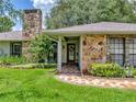 Inviting front entrance features stone accents, manicured landscaping, and a welcoming walkway at 1308 Timberidge N Loop, Lakeland, FL 33809