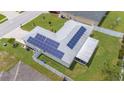 Aerial view of home with solar panels installed on the roof and a screened lanai at 1420 Meadows Pond Dr, Bartow, FL 33830