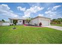 Inviting single-story home featuring a well-manicured lawn, landscaping and an attached two-car garage at 1420 Meadows Pond Dr, Bartow, FL 33830