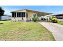 Inviting home with a cozy screened porch, carport, and lush front yard at 1811 Sherwood Hill Dr, Lakeland, FL 33810