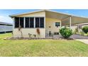 A quaint home featuring a screened porch and a covered carport at 1811 Sherwood Hill Dr, Lakeland, FL 33810