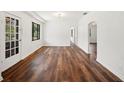 Spacious living room featuring rich wood floors, fresh white walls, natural light and stylish glass paneled doors at 1830 Casco, Lakeland, FL 33801