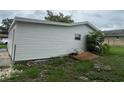Rear view of the house showing the siding and the yard in need of landscaping at 1938 Lavon St, Lakeland, FL 33805