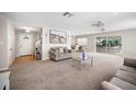 Open-concept living room with carpet, featuring a cozy seating area and access to dining area with a view to lanai at 1948 Oakland Park Dr, Lake Wales, FL 33898