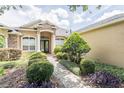 Elegant home exterior showcasing a well-manicured front yard and stone and stucco detailing near the entrance at 2026 Indian Sky Cir, Lakeland, FL 33813