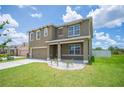 Charming two-story home with a well-manicured lawn, neutral exterior, and two-car garage at 2062 Blue Highlands Dr, Lakeland, FL 33811