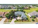 A beautiful single-story home featuring mature landscaping, a brick driveway, and a cozy front porch at 2817 High Winds Ln, Lakeland, FL 33813