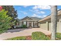 Beautiful one-story home featuring a brick driveway, a well-manicured lawn and tidy landscaping at 2817 High Winds Ln, Lakeland, FL 33813