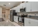 Modern kitchen featuring white cabinets, stainless steel appliances, and granite countertops at 2958 Flying Blackbird Rd, Bartow, FL 33830