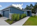 A charming home with stone accents and a well-manicured lawn leading to the front door at 312 Walnut Ln, Auburndale, FL 33823