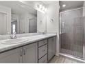 Bathroom featuring double vanity sinks, a large mirror and a walk-in shower at 3135 Laurel Oak Ln, Winter Haven, FL 33884