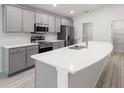 Modern kitchen with sleek gray cabinets, quartz countertops, and stainless steel appliances at 3135 Laurel Oak Ln, Winter Haven, FL 33884