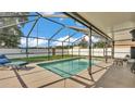 Backyard pool area with an enclosed screen featuring chairs for relaxing outdoors at 3787 Sandhill Crane Dr, Lakeland, FL 33811