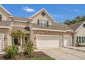 Charming townhouse featuring stone accents, attached garages and well maintained landscaping under a bright blue sky at 4309 Shipp Ct, Lakeland, FL 33813
