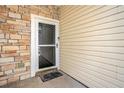 A close up on the front door featuring a clear glass storm door and stone and siding exterior at 4309 Shipp Ct, Lakeland, FL 33813