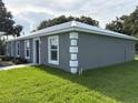 Side angle of the exterior of the duplex, showing the manicured lawn and gray facade at 508 & 510 2Nd Sw St, Fort Meade, FL 33841