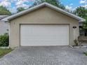 Two-car garage with a brick paver driveway and well-manicured landscaping enhancing curb appeal at 5522 1St Se St, Lakeland, FL 33812