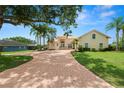 Spacious two-story home with a brick driveway, mature trees, and lush green lawn at 6217 Ashley Dr, Lakeland, FL 33813