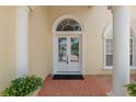 Elegant front entrance with double doors, arched transom window, and brick paver walkway at 6217 Ashley Dr, Lakeland, FL 33813