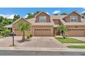 Attractive townhome showcasing a well-maintained brick driveway and colorful tropical landscaping at 6365 Torrington Cir, Lakeland, FL 33811