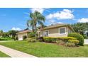 Exterior home showcasing lush landscaping, a well-manicured lawn, and mature palm trees at 6757 High Grove Dr, Lakeland, FL 33813