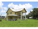 Exterior shot of home with wraparound porch, large columns and metal roof at 701 1St Ne St, Fort Meade, FL 33841