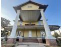 Two-story home featuring a symmetrical front porch and tall white columns with brick supports at 701 1St Ne St, Fort Meade, FL 33841
