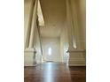 Foyer with high ceilings, large white columns, and a dark wood floor leading to a white front door at 701 1St Ne St, Fort Meade, FL 33841