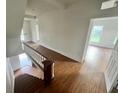 Hallway features hardwood floors, a staircase with a white railing, and natural light coming from the large window at 701 1St Ne St, Fort Meade, FL 33841