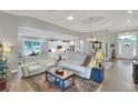 Bright and open living room with tray ceilings, neutral decor, hardwood floors and seamless flow to the kitchen at 7770 Lake James Blvd, Lakeland, FL 33810