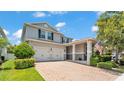 Two-story home boasting a manicured lawn, brick-paved driveway, and a two-car garage at 8120 Soldierwood St, Winter Garden, FL 34787