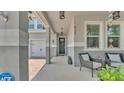 Covered front porch showing a seating area and view of a two-car garage and front door at 8120 Soldierwood St, Winter Garden, FL 34787