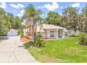 Well-kept home with a lovely front yard, palm tree, and a detached garage at 1102 Berkley Ln, Winter Haven, FL 33880