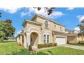 Stucco two-story home with well maintained lawn and two-car garage at 141 Minniehaha Cir, Haines City, FL 33844