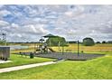 Community playground with swings, slides, and green lawn area at 1497 Leamington Ln, Winter Haven, FL 33884