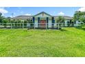 Home exterior featuring a well-maintained lawn and a white fence, offering a tranquil and inviting curb appeal at 15195 Angus Rd, Polk City, FL 33868