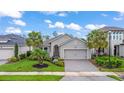 Charming single-story home featuring a paved driveway, well-maintained lawn, and tasteful landscaping at 180 Azure Mist Way, Daytona Beach, FL 32124