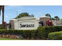Stone community entrance sign, manicured landscaping, sunny skies, and palm trees at Sawgrass at 2169 Rush Bay Way, Orlando, FL 32824