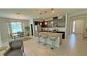 Open-concept kitchen boasts a large center island, modern appliances, and pendant lighting at 2169 Rush Bay Way, Orlando, FL 32824