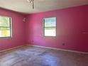Bedroom with pink walls and two windows, in need of renovation at 2250 Maple Hill Dr, Lakeland, FL 33811
