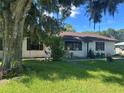Cozy single-story home with a well-maintained lawn and mature tree in the front yard at 2250 Maple Hill Dr, Lakeland, FL 33811
