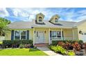 Inviting front porch of a yellow house featuring classic columns, black sconces, and colorful landscaping at 2264 Palmview E Cir, Auburndale, FL 33823