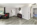 Open-concept living room boasts gray flooring, neutral walls, and a cozy armchair at 2443 Delrose E Dr, Lakeland, FL 33805