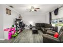 Spacious living room with gray flooring, comfortable seating, and a large entertainment center at 2443 Delrose E Dr, Lakeland, FL 33805