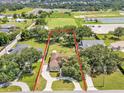 An aerial view showcases the home's well-manicured lawn, circular driveway, mature trees and proximity to the nearby sports field at 2533 Peterson Rd, Lakeland, FL 33812